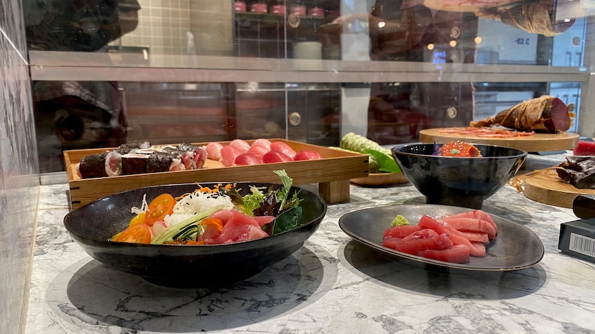 Tuna dishes on display in a glass cabinet.