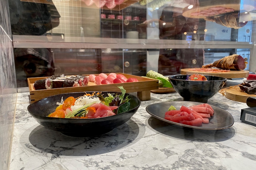 Tuna dishes on display in a glass cabinet.
