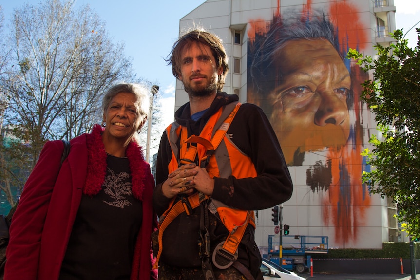 Jenny Munro with artist Matt Adnate in front his mural in Sydney CBD
