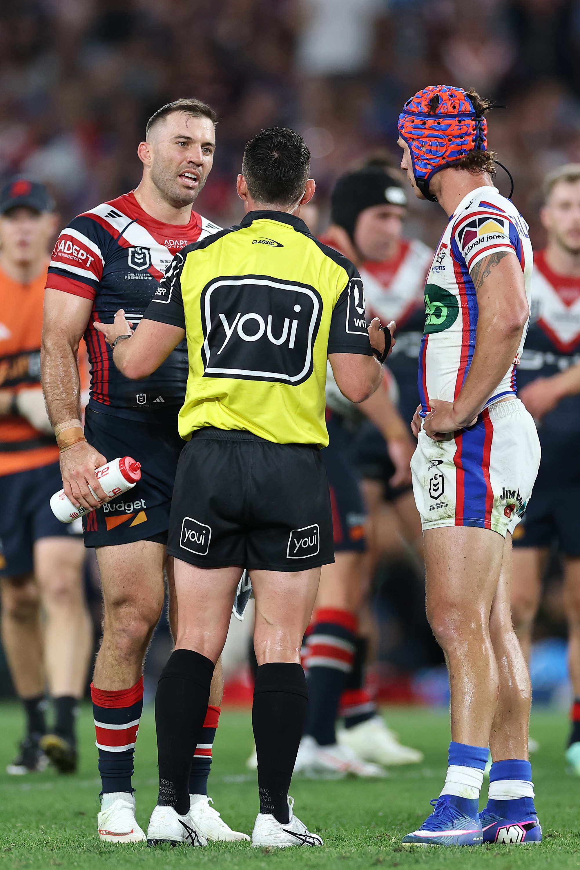 Referee talks to pair of captains during an NRL grand final