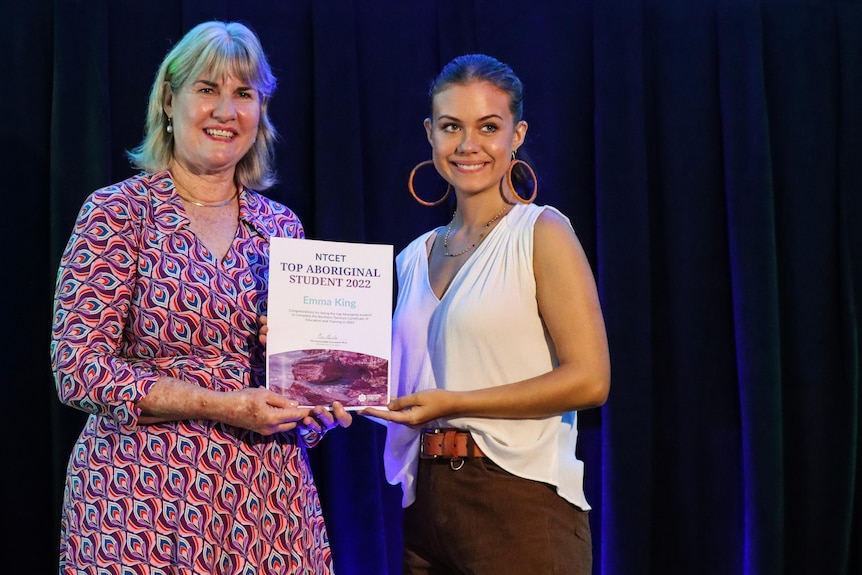 Eva lawler stands with Emma King at an awards ceremony.