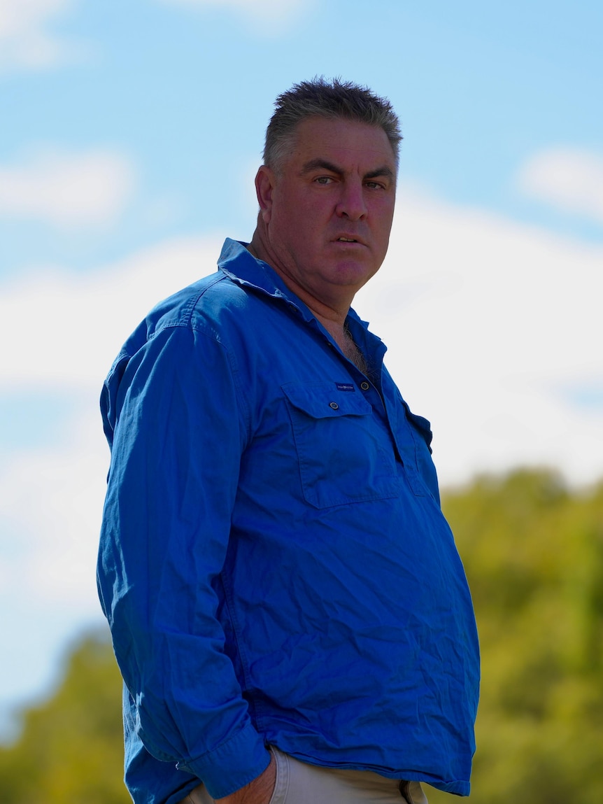 A white man in a blue shirt on a blue sky day 