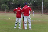 Members of the Yirrkala cricket team stand in their cricketing uniforms on the day of the match.