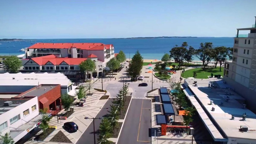 An aerial shot of a town centre foreshore looking out towards the beach