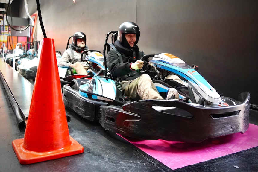 A father and son sit in go-karts.