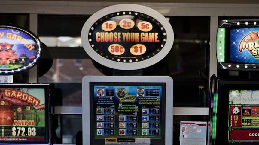 A woman plays a poker machine