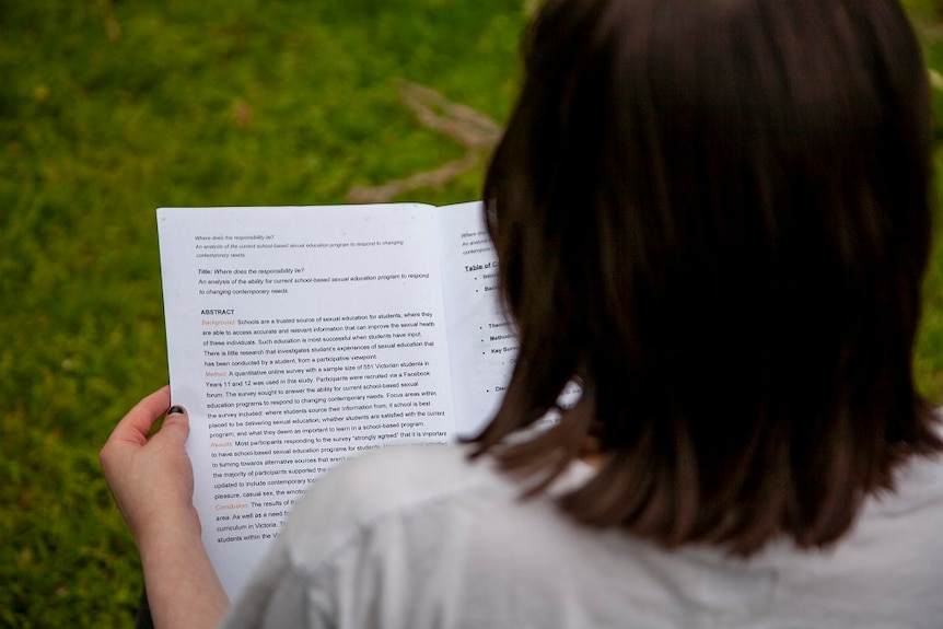 A girl reads an assignment and turns the page