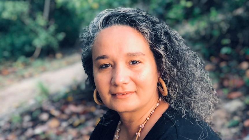 Aboriginal woman looks at camera with curly hair out