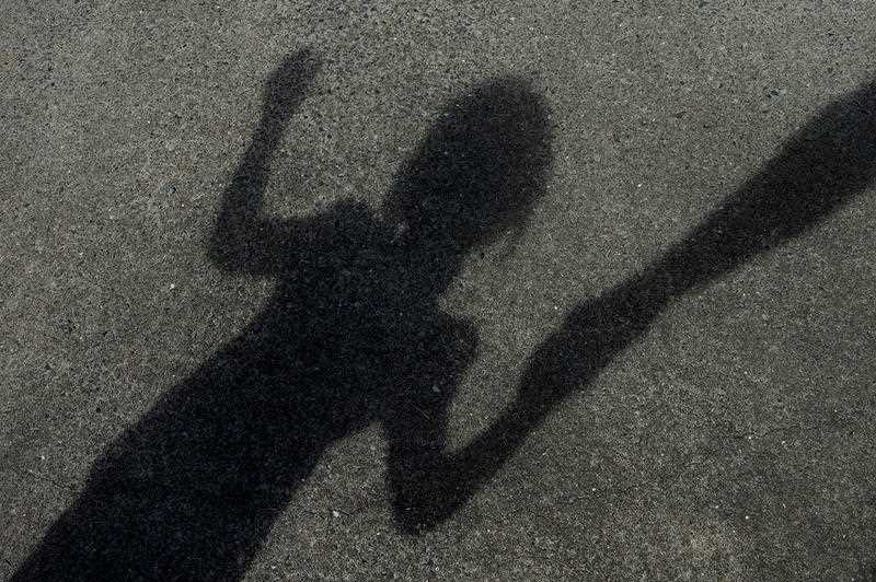 A shadow of a child holding on to an adults hand.
