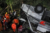 Rescue personnel work at the crash site after a bus fell into a ravin
