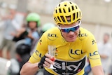 Team Sky rider and yellow jersey Chris Froome of Britain holds a glass of champagne.