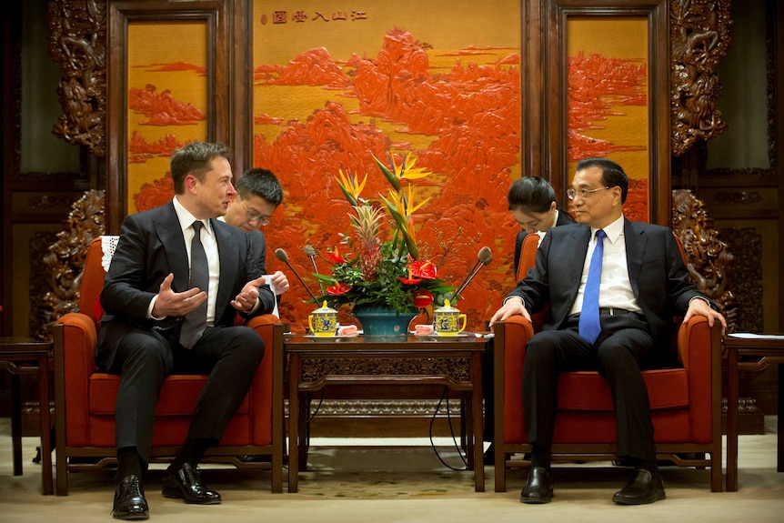 Tesla CEO Elon Musk and Chinese Premier Li Keqiang talking to each other
