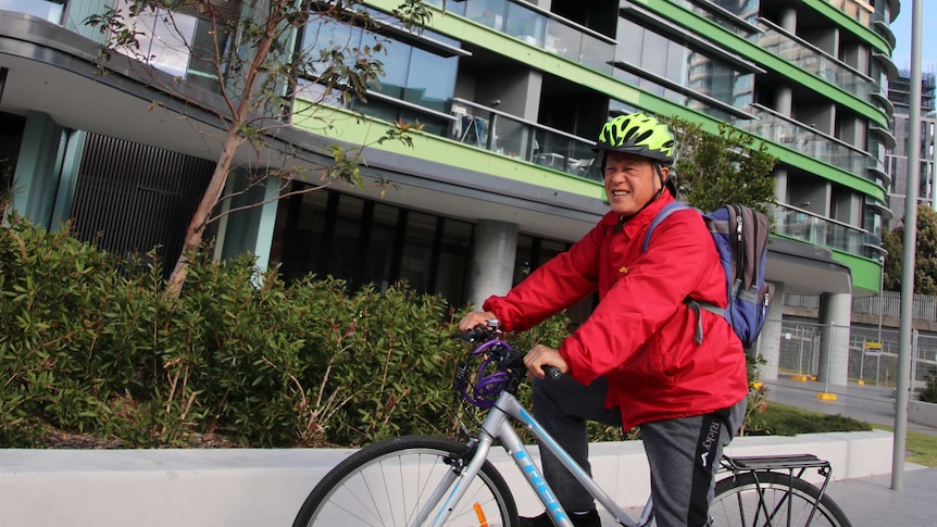 Opal Tower resident Andre on a bike outside the building