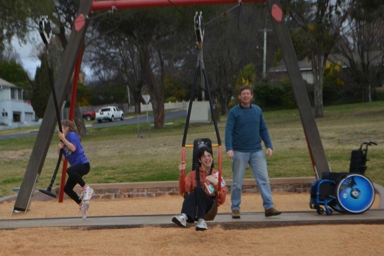 Braedon Jones on a flying fox designed for someone with a disability alongside his sister on a traditional flying fox.