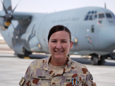 An army soldier standing in front of a plane.