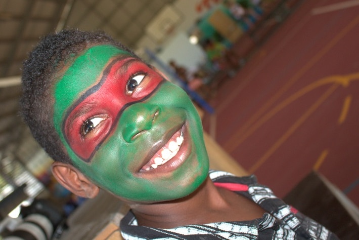 A young boy smiling at the camera with his face painting in Mapoon on Australia Day
