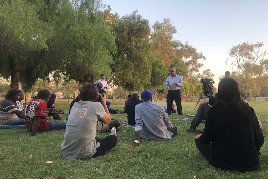 Ken Wyatt stands in front of a sitting group of people in a park and takes questions