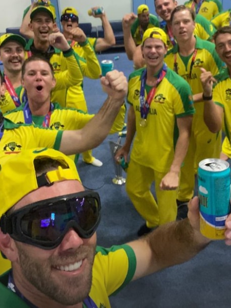 Glen Maxwell takes a selfie and holds up a can of beer wearing dark ski goggles in front of his Australia teammates
