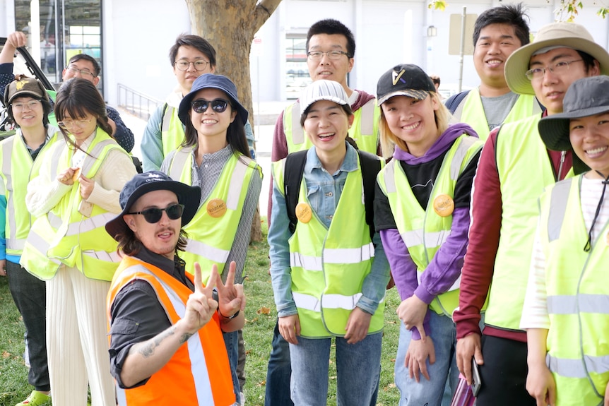 Photograph of a group of people wearing high vis clothing, with one person doing thumbs up at the camera.
