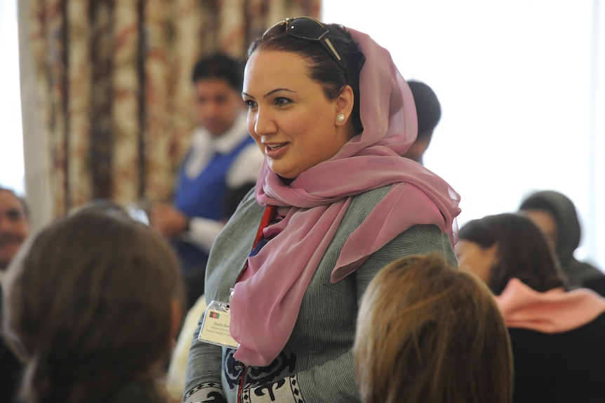 Shukria Barakzai talks to people indoors.