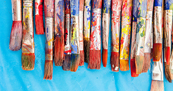 A close-up of a painter's messy brushes.