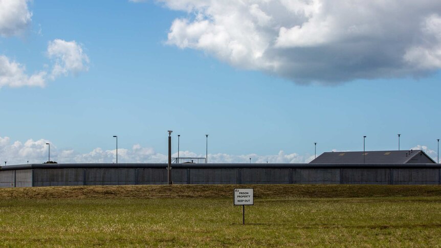A sign reads 'PRISON PROPERTY KEEP OUT' in front of walls surrounding Port Phillip Prison.