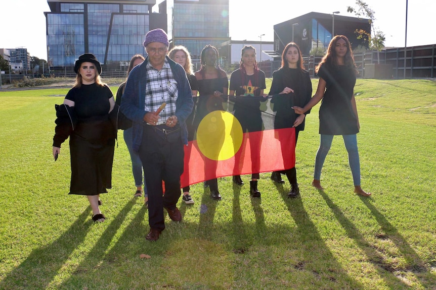 Organisers of the Perth Black Lives matters rally for June 13 walk together holding an Aboriginal flag.