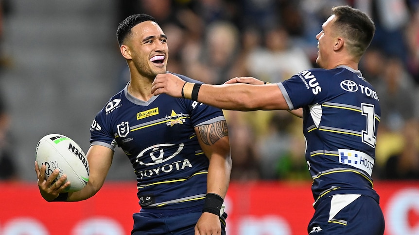 Two North Queensland Cowboys NRL players celebrate a try against Penrith.