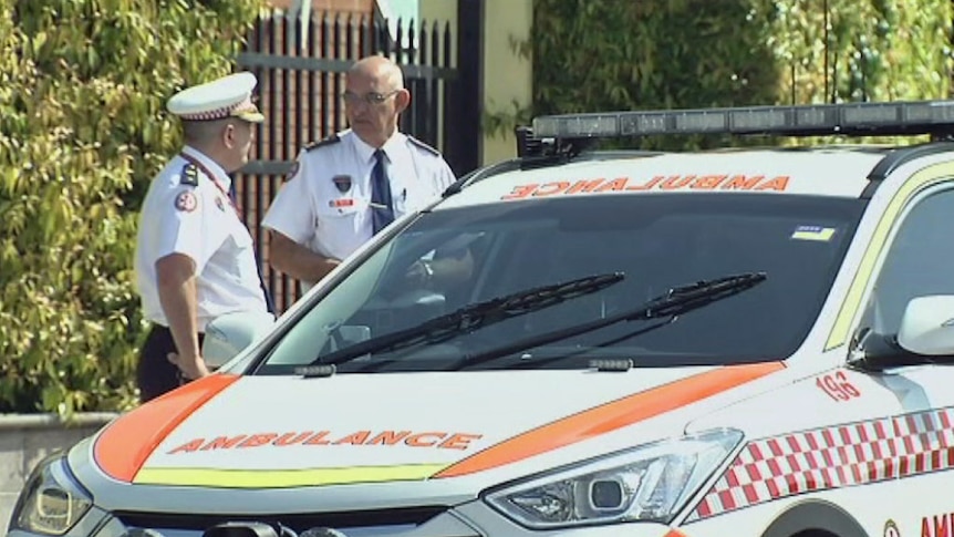 Ambulance officers outside a Catholic school at West Hoxton, where students were taken to hospital after lightning strikes nearby