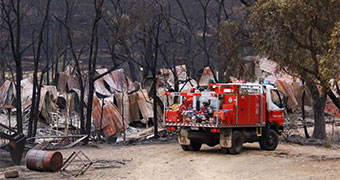 A fire truck outside a burnt-out home in the Carwoola fire.