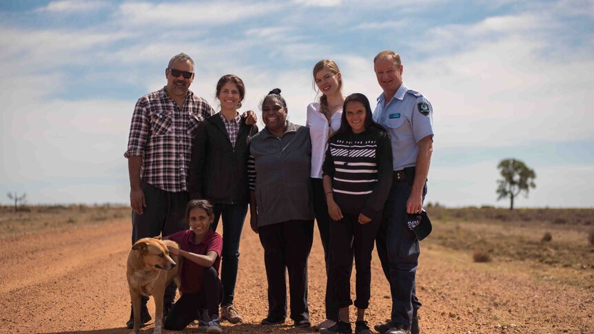 Actors and director, Imogen Thomas, stand on dirt road at Brewarrina.