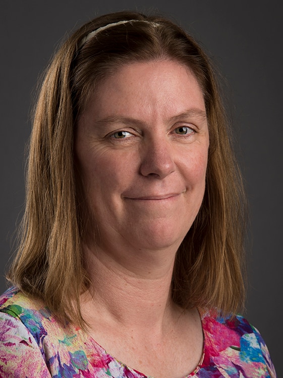 A woman wearing a colourful shirt.