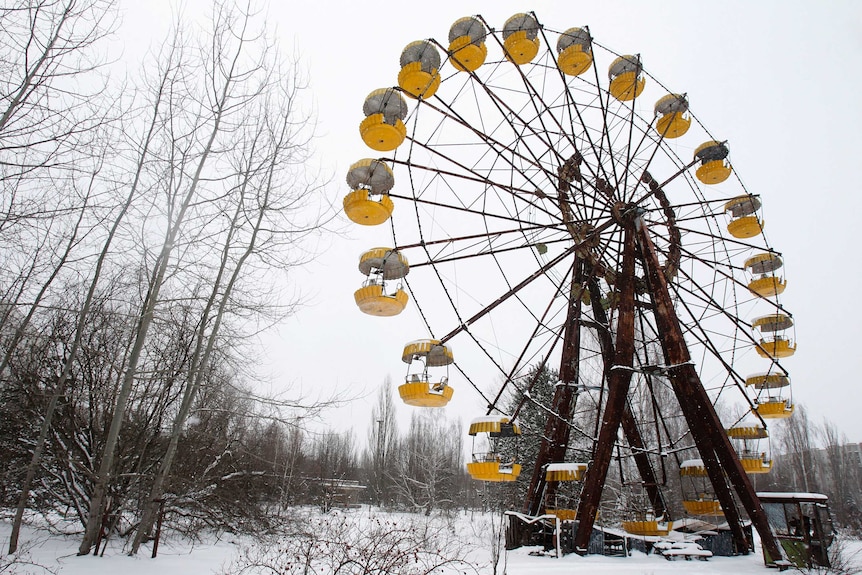 An abandoned ferris wheel in the snow.
