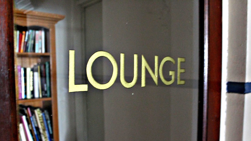 Close up image of Lounge printed in gold lettering on glass door.
