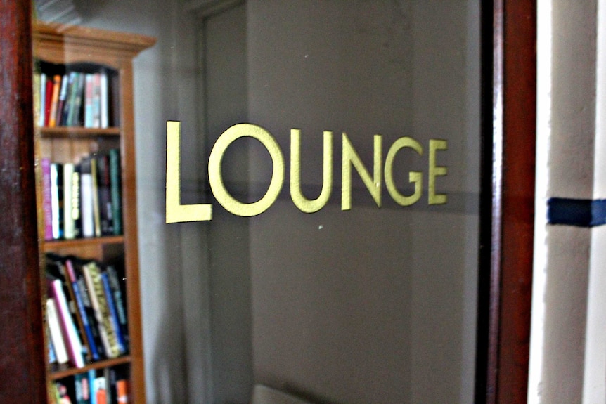 Close up image of Lounge printed in gold lettering on glass door.