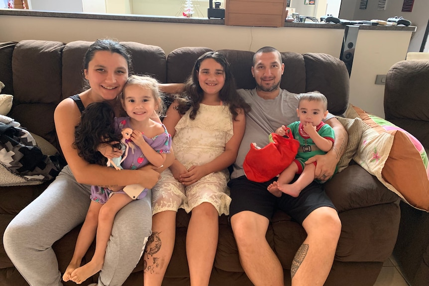 Steve Bastian with his four children, all sitting on a brown couch.