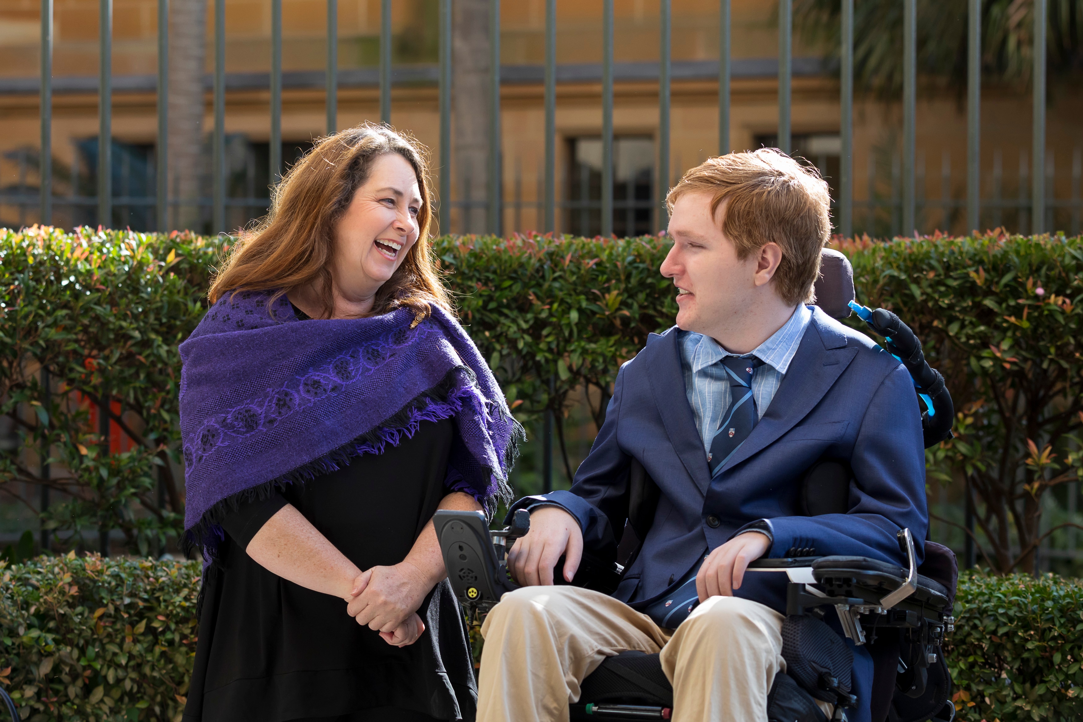 Woman smiling at man sitting in wheelchair 
