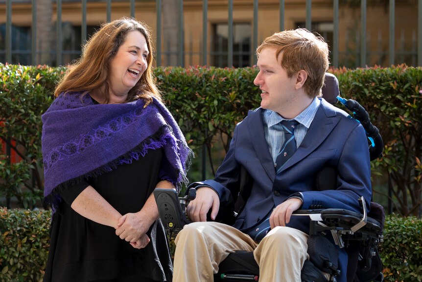 Woman smiling at man sitting in wheelchair 