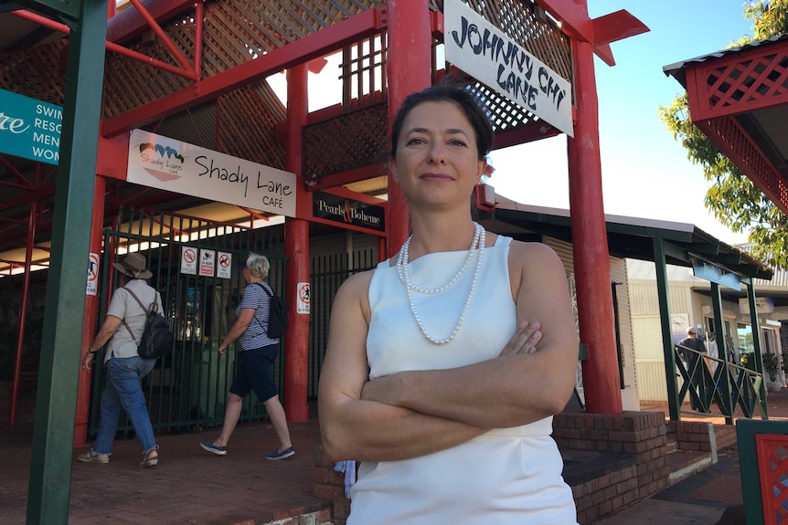 Broome CCI chief executive Jael Napper in a white dress in front of Johnny Chi Lane.