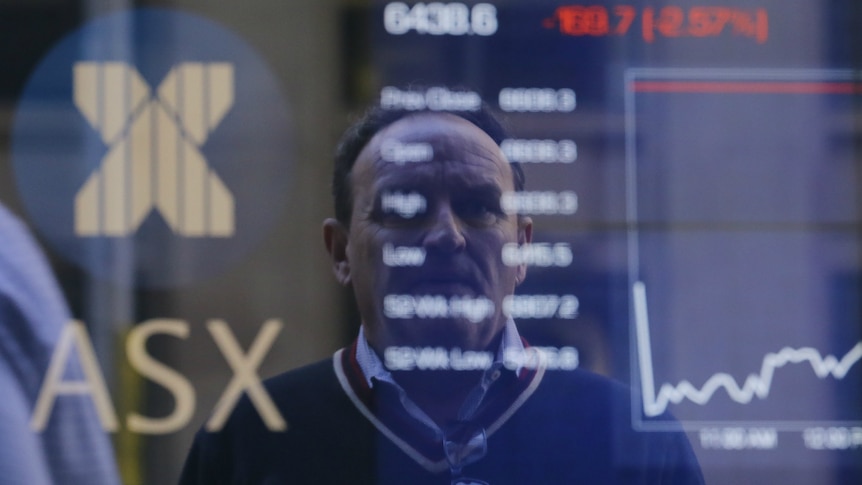 Pedestrians are reflected in a window with an indicator board displaying stock prices at the Australian Stock Exchange in Sydney