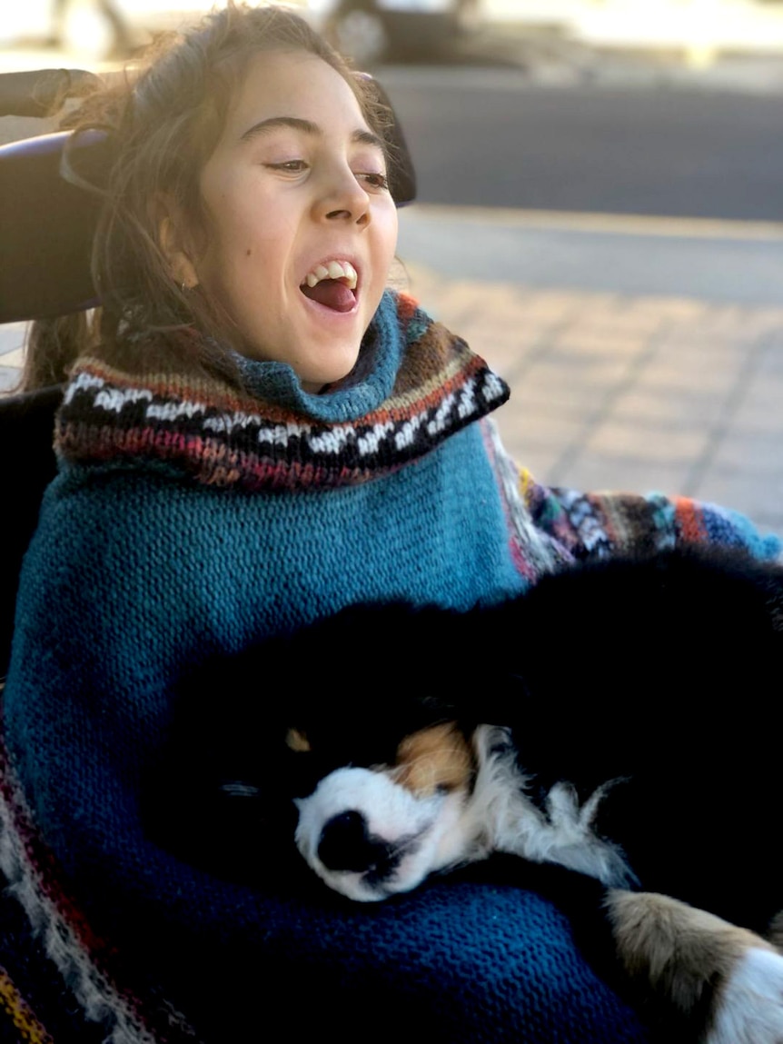 13-year-old Jessica Armitstead in her wheelchair with her dog.