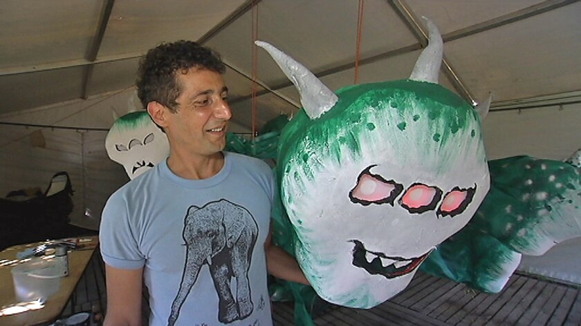 Daniele Poidomani with a 10-headed monster sculpture
