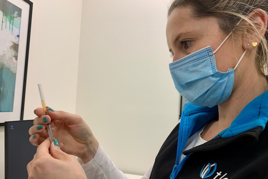 Nurse looking at a COVID vaccine