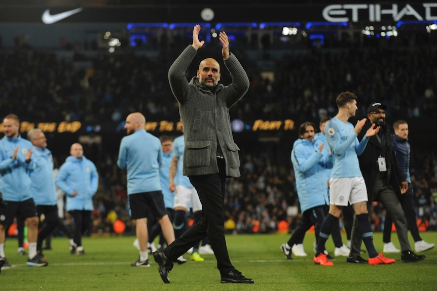 A football manager applauds the fans after his team's victory
