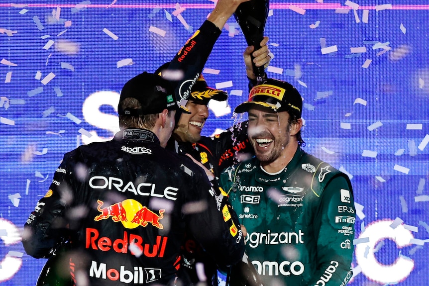 Fernando Alonso celebrates on the podium in Saudi Arabia, with champagne poured over his head