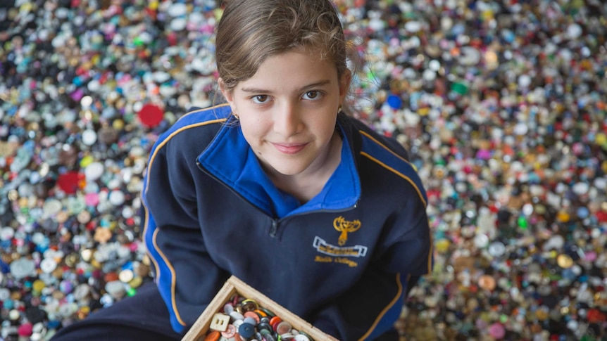 Grade five student Mia Rom surrounded by buttons