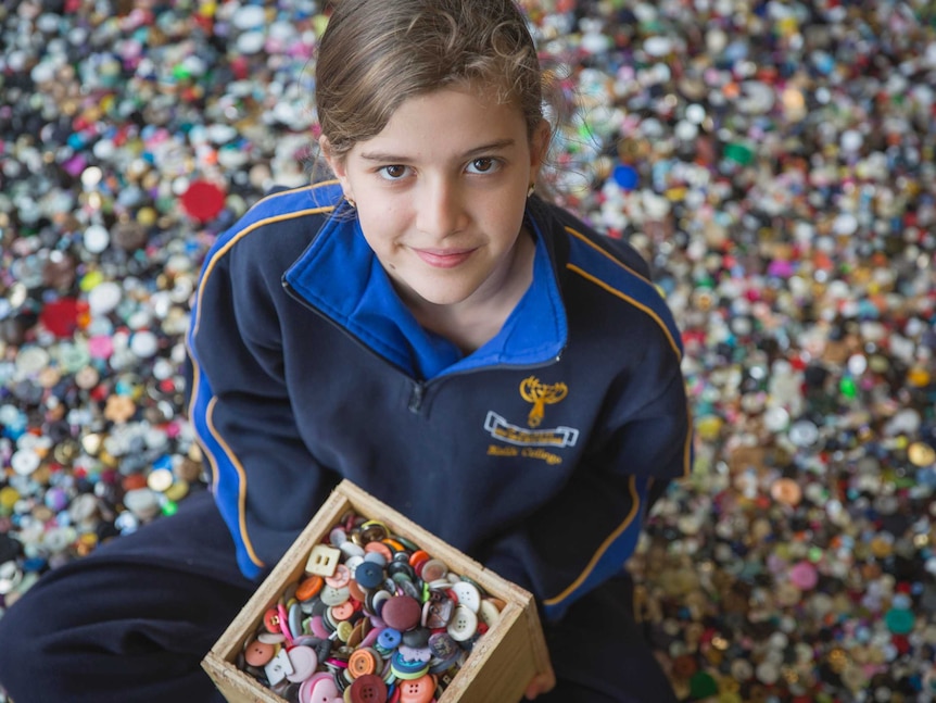 Grade five student Mia Rom surrounded by buttons