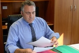 Federal Treasurer Joe Hockey looking through budget materials