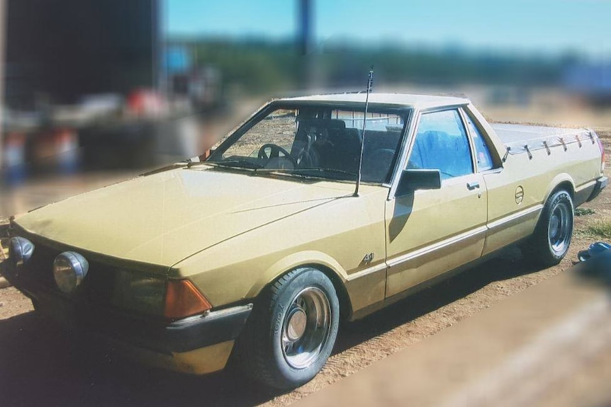 yellow utility car parked on dirt and grass