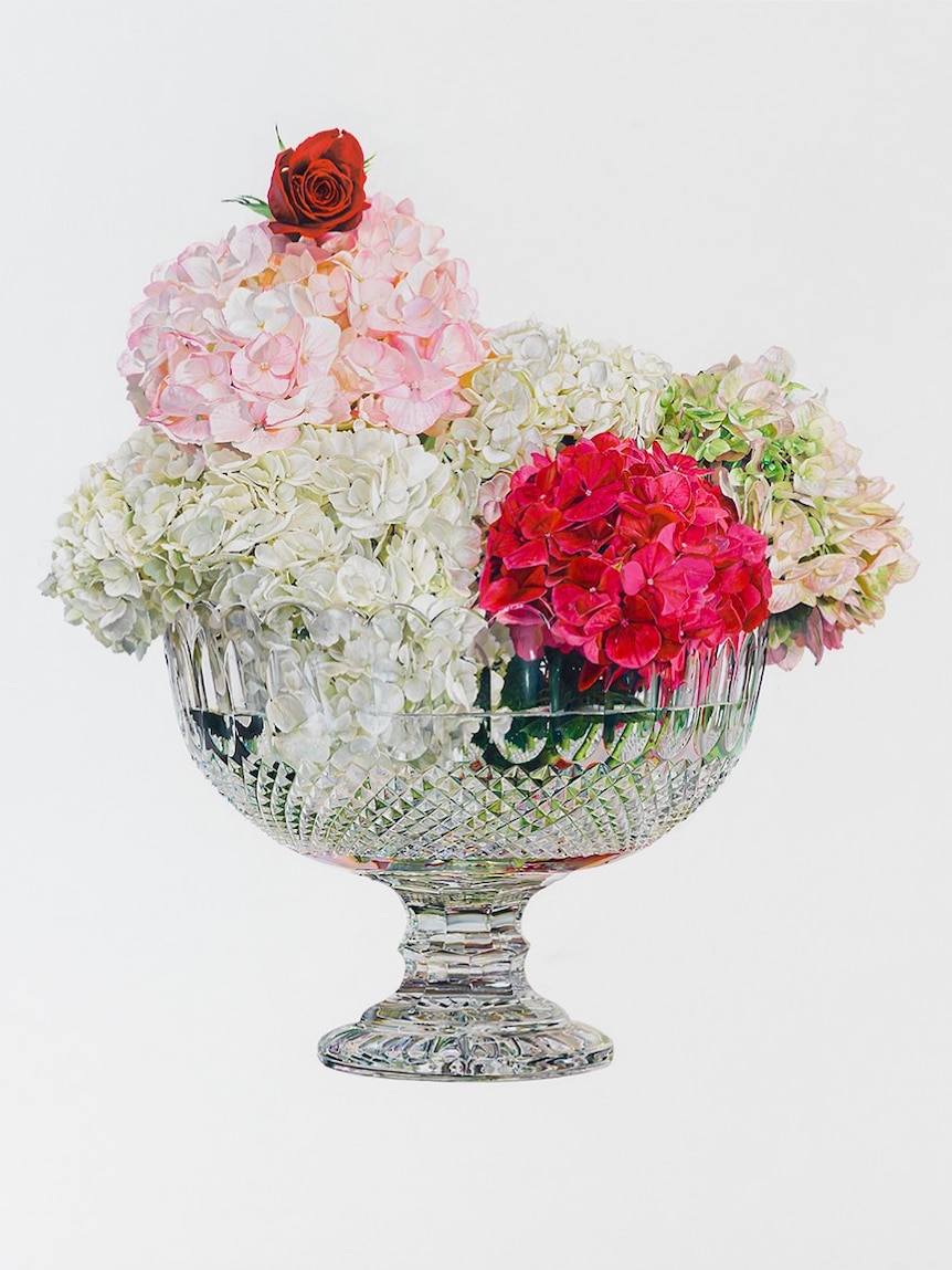 A crystal glass with hydrangea flowers in it arranged to look like an ice cream sundae.
